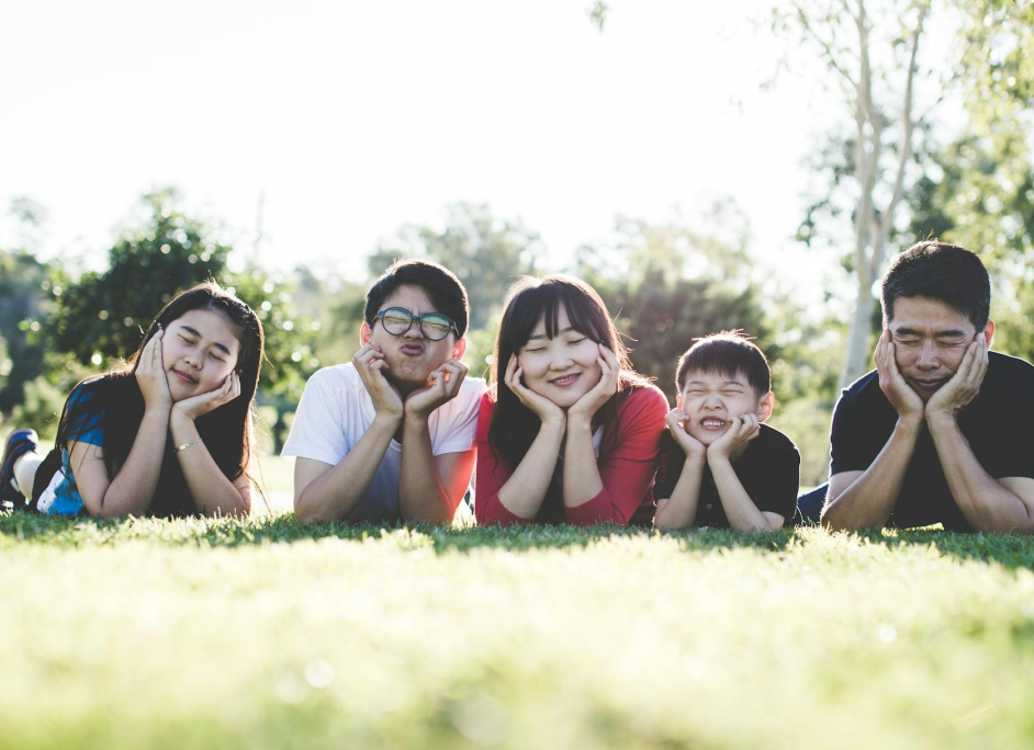 Group of smiling children lying together on grass