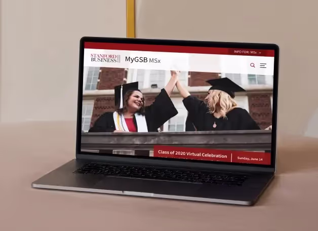 A laptop showing the MyGSB MSx portal home page with a graduation photograph