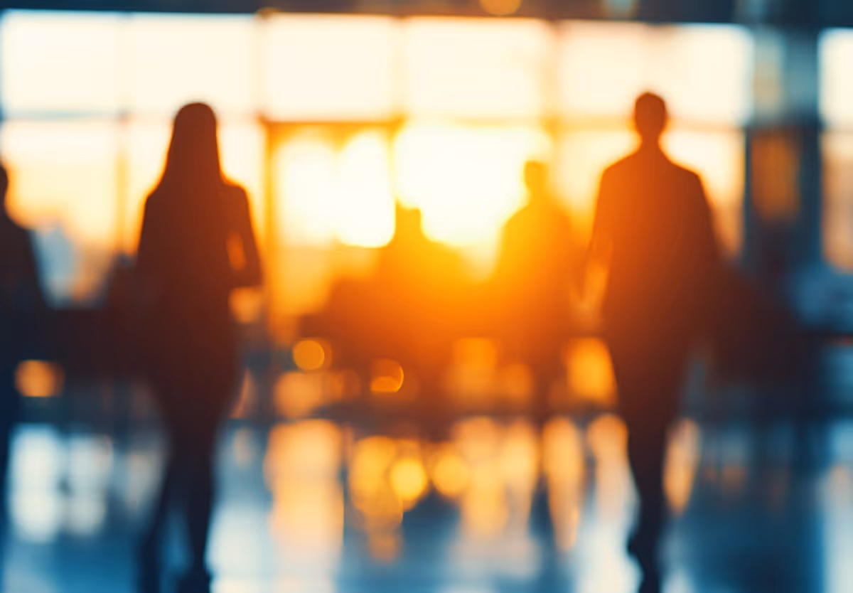 Silhouetted professionals walking through a sunlit office corridor, representing a senior engineering team joining an active delivery environment.